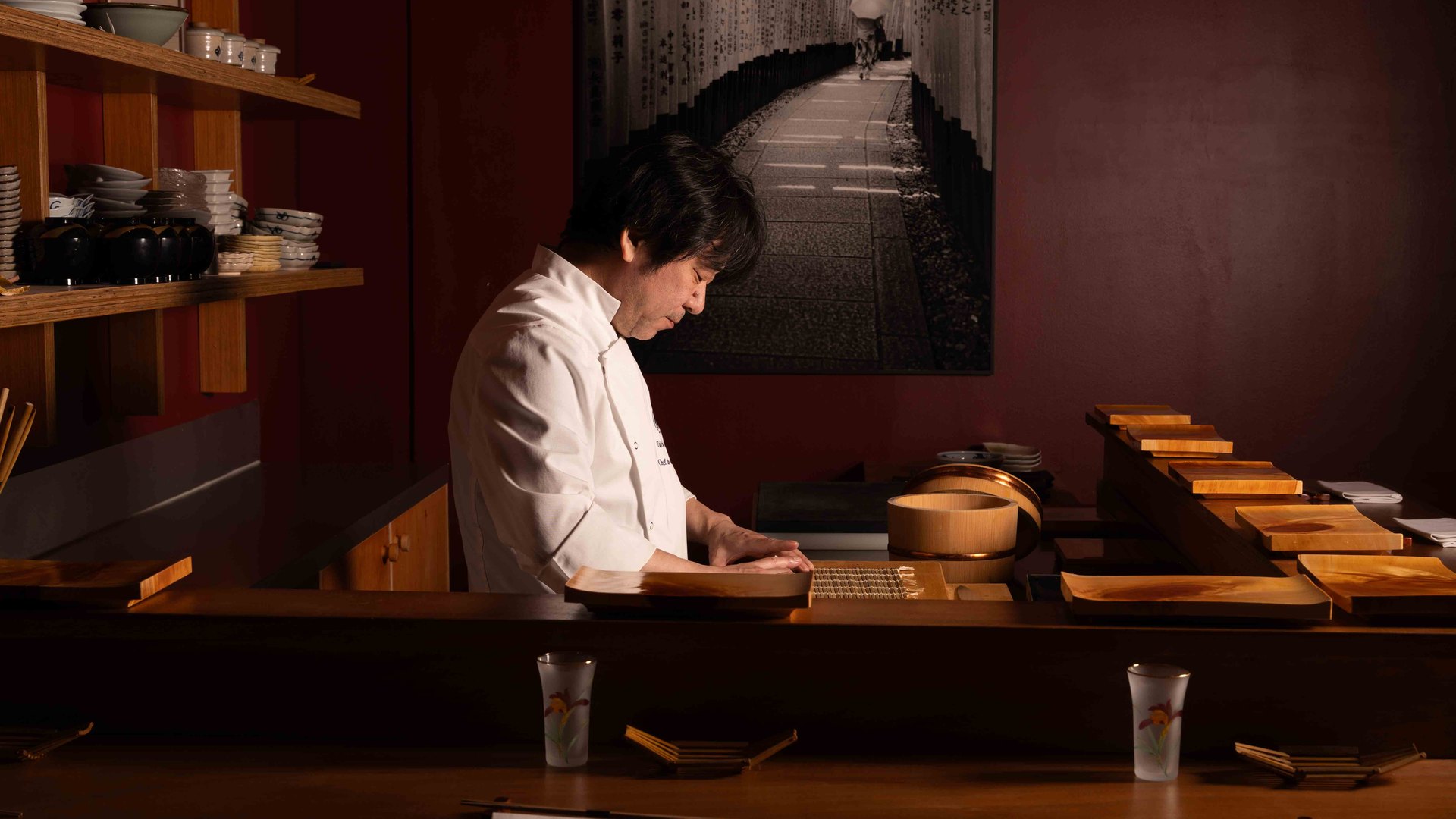 Le chef au comptoir de Saku, sous la photo du torii — omakase rue du Mont-Thabor